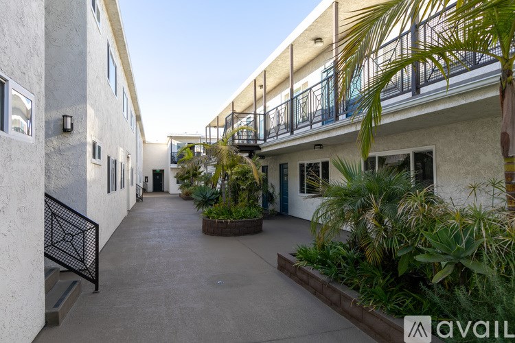 A balcony with a railing and plants on the ground.