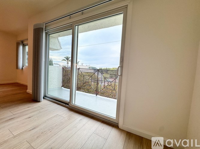 A room with a sliding glass door leading to a balcony.