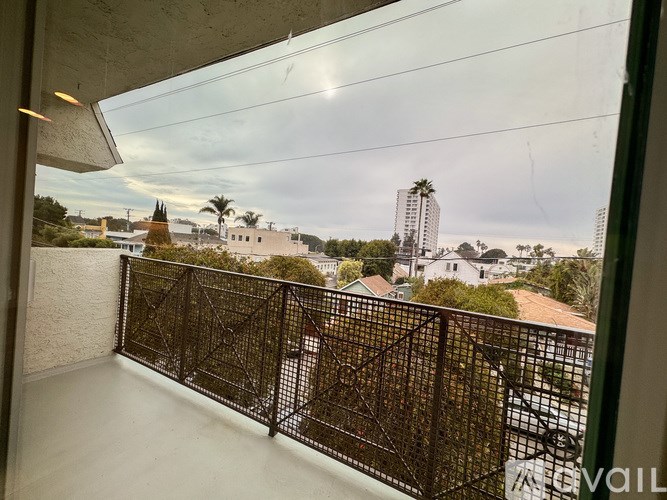 A balcony with a metal railing overlooks a cityscape.