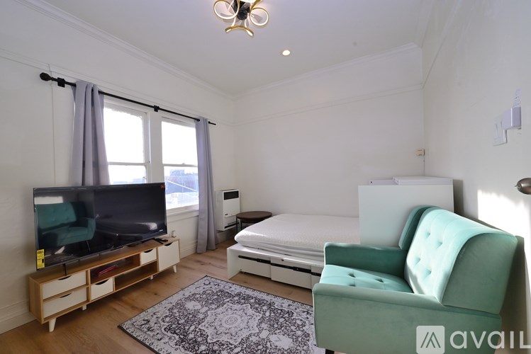A living room with a green chair and a white bed.
