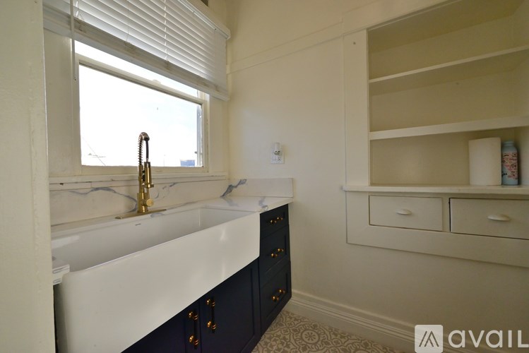 A bathroom with a white sink and a window.