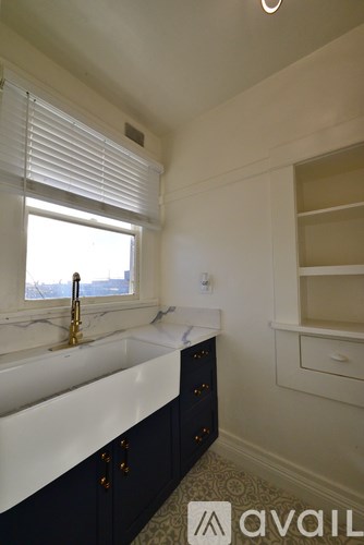 A bathroom with a sink, a window, and a cabinet.