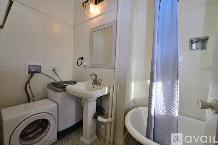 A bathroom with a washing machine and a sink.