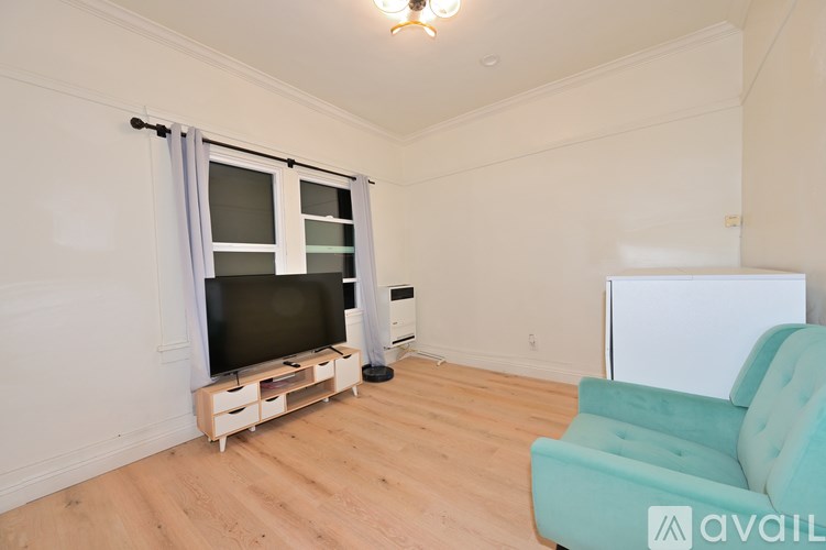 A room with a television, a sofa, and a whiteboard.