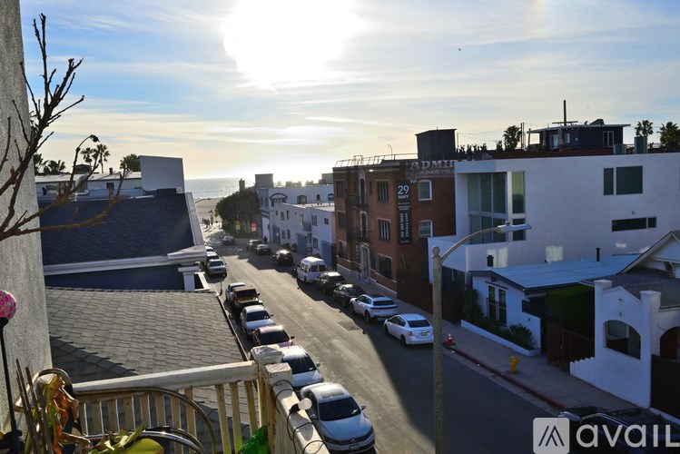 A street view of a residential area with cars parked on the side of the road.