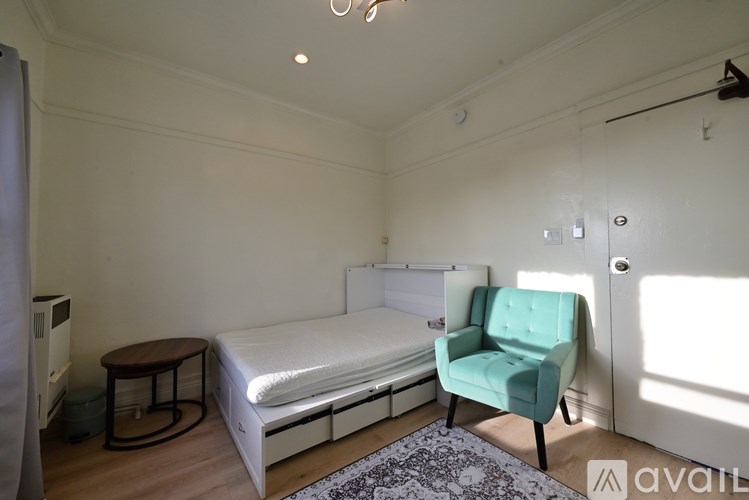 A bedroom with a bed, chair, and table.