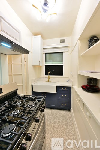 A kitchen with a black stove top and white cabinets.
