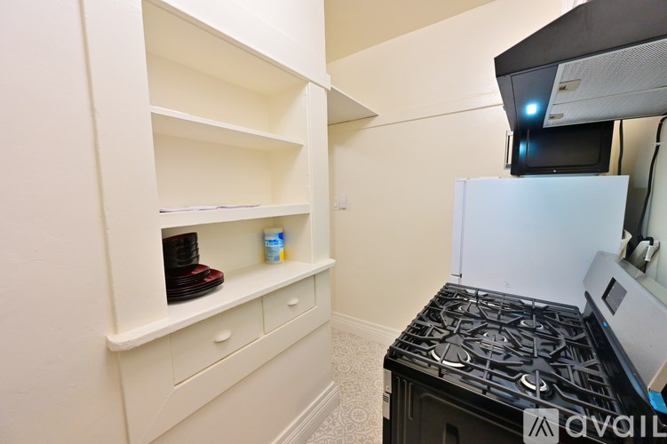 A kitchen with a black stove top and white cabinets.