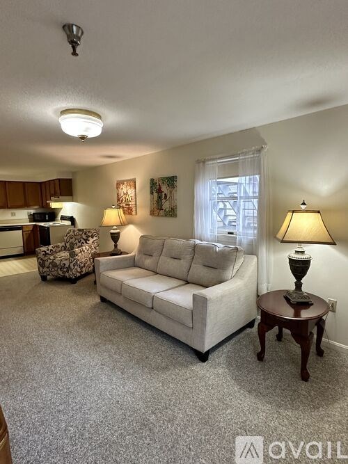 A living room with a couch, chair, and lamp.