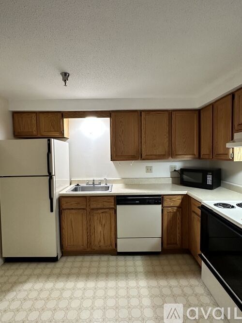 A kitchen with wooden cabinets and a white refrigerator.