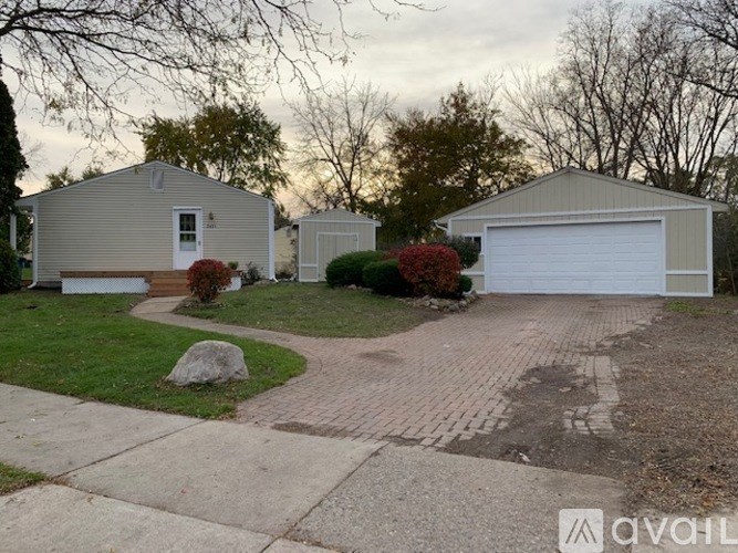 A house with a garage and a driveway in front of it.