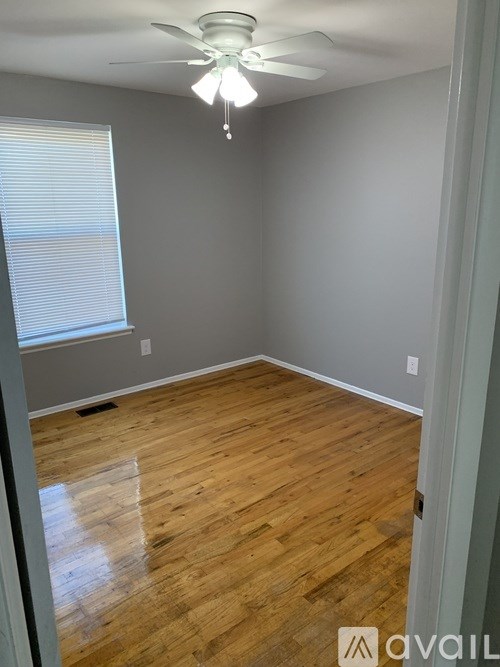 A room with wooden flooring and a ceiling fan.
