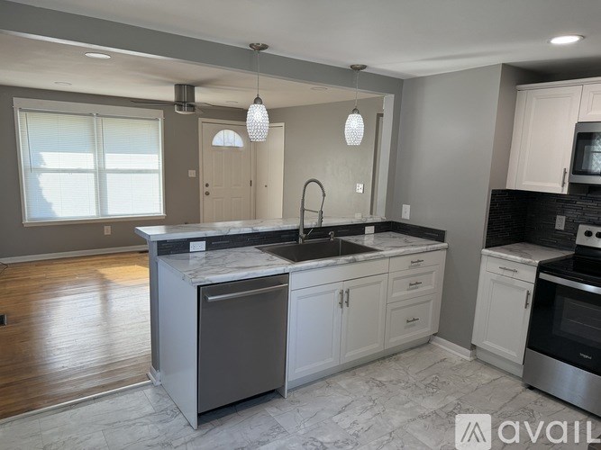A modern kitchen with a large island and stainless steel appliances.