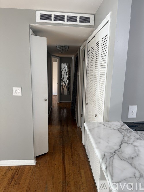 A hallway with a marble bench and a white door.