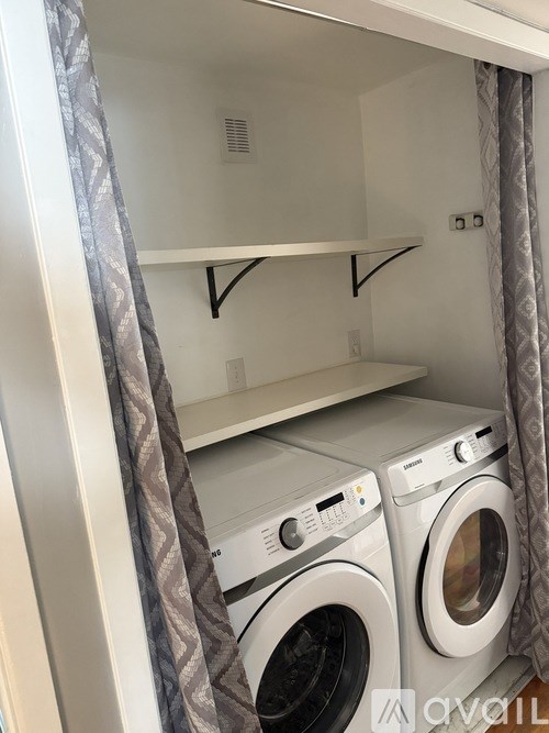 A washing machine is sitting in a cabinet.