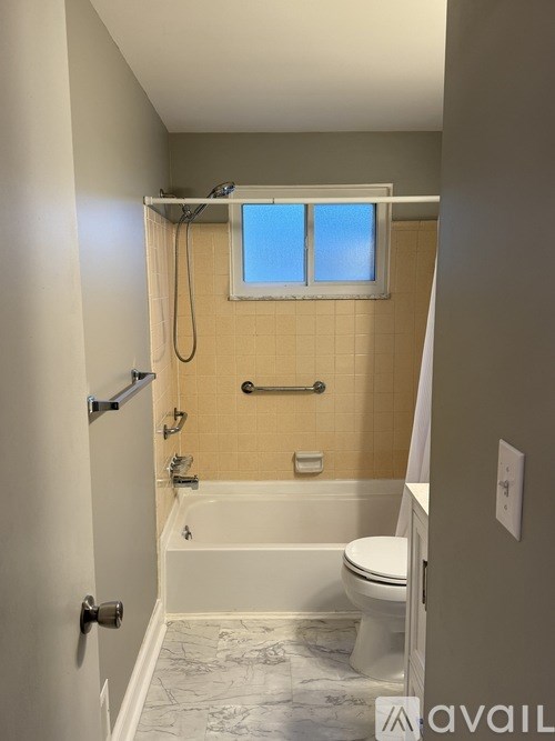 A bathroom with a tub, toilet, and sink.