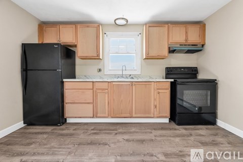 A kitchen with wooden cabinets and black appliances.