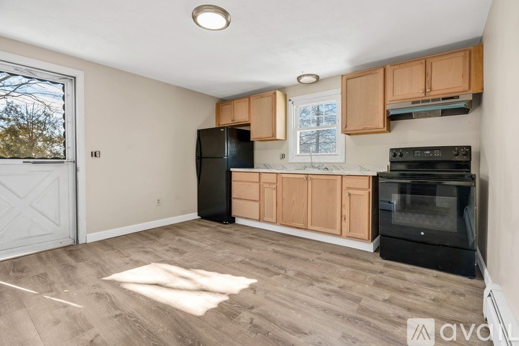 A kitchen with wooden cabinets and black appliances.