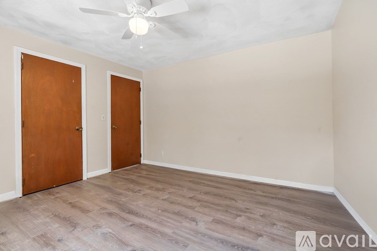 A room with a ceiling fan and two doors.