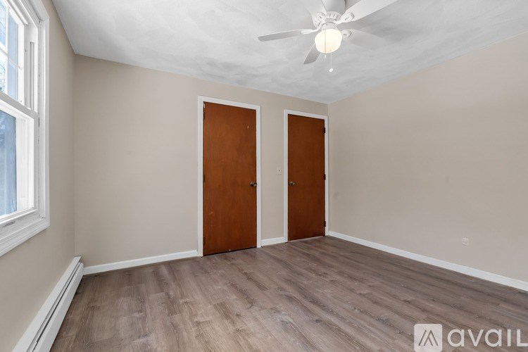 A room with a ceiling fan and two doors.