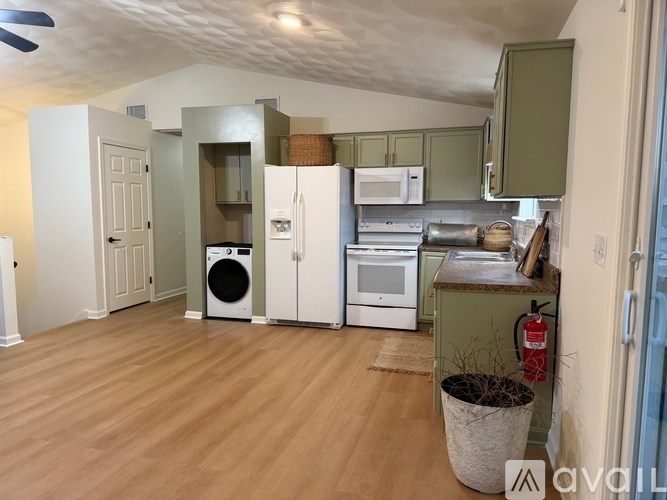 A kitchen with wooden floors and green cabinets.