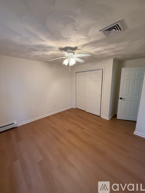 A room with a ceiling fan and two doors.
