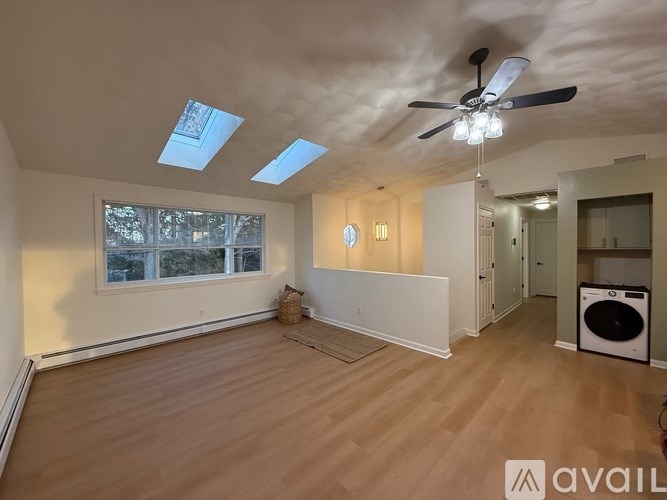 A room with a ceiling fan and skylights.