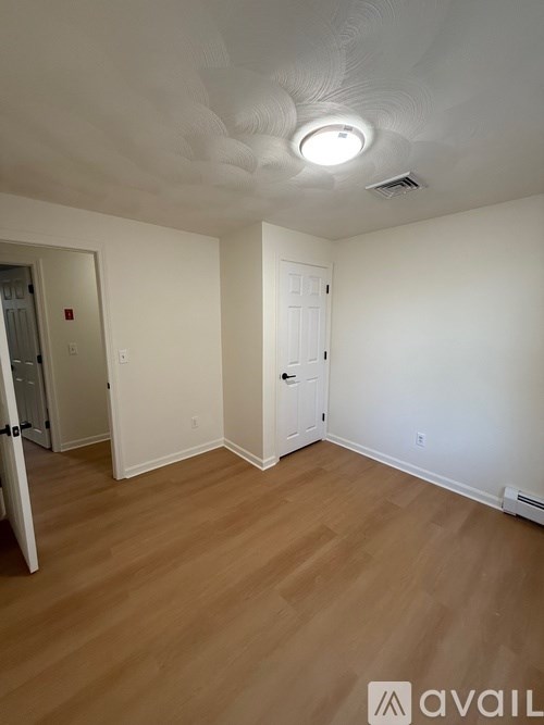 A room with a white ceiling and wooden flooring.