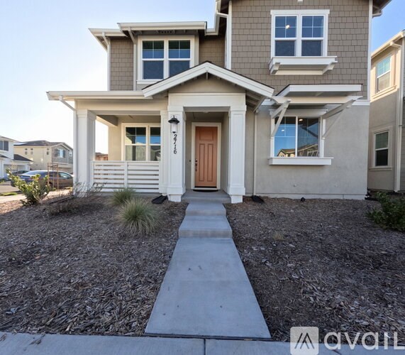 A modern house with a brown door and a grey roof.