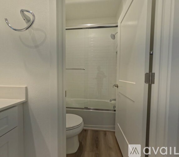 A white bathroom with a toilet, sink, and shower.