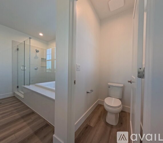 A white toilet in a bathroom with a glass shower door.