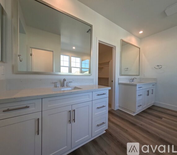 A bathroom with a sink, mirror, and cabinets.