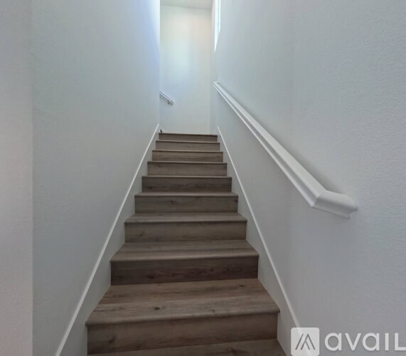 A staircase with wooden steps and white walls.