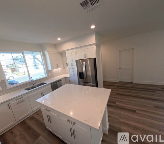 A kitchen with white cabinets and a large island.