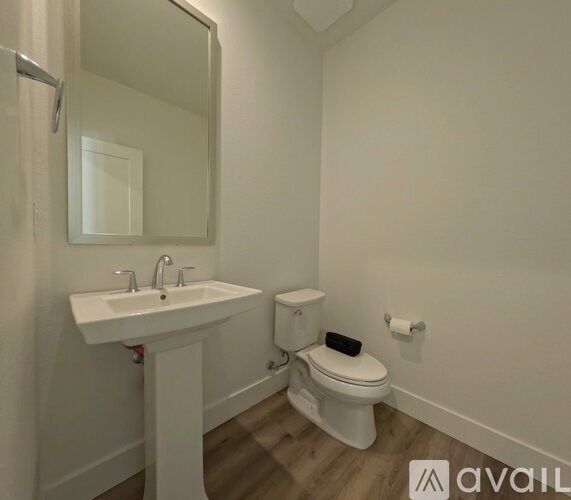 A white bathroom with a sink, toilet, and mirror.