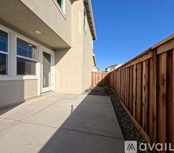 A house with a wooden fence and a clear blue sky.