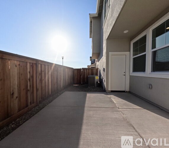 A sunny day with a clear blue sky and a wooden fence.