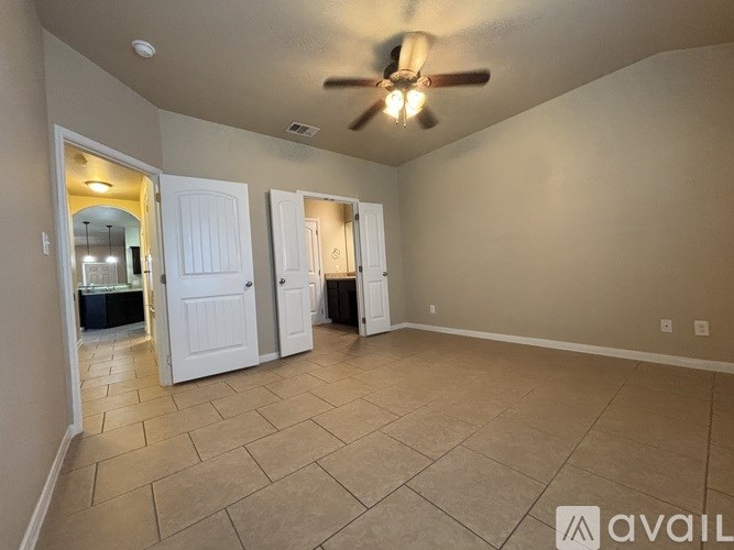 A room with a ceiling fan and tile flooring.