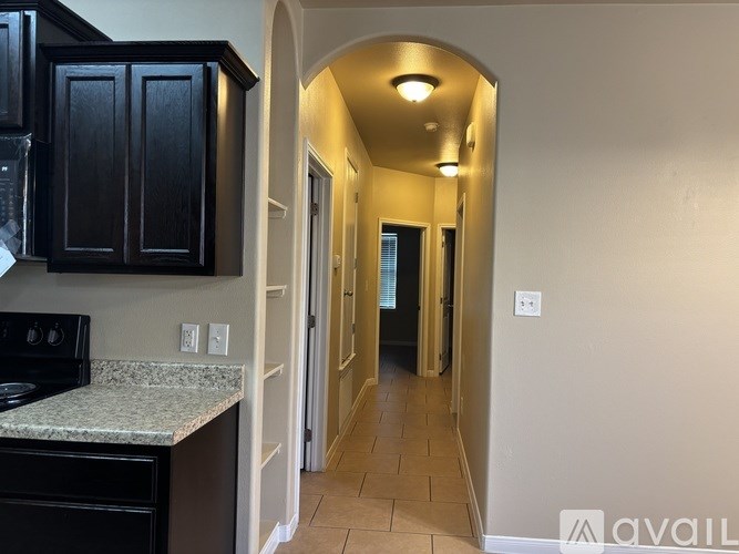 A kitchen with black cabinets and a granite countertop.