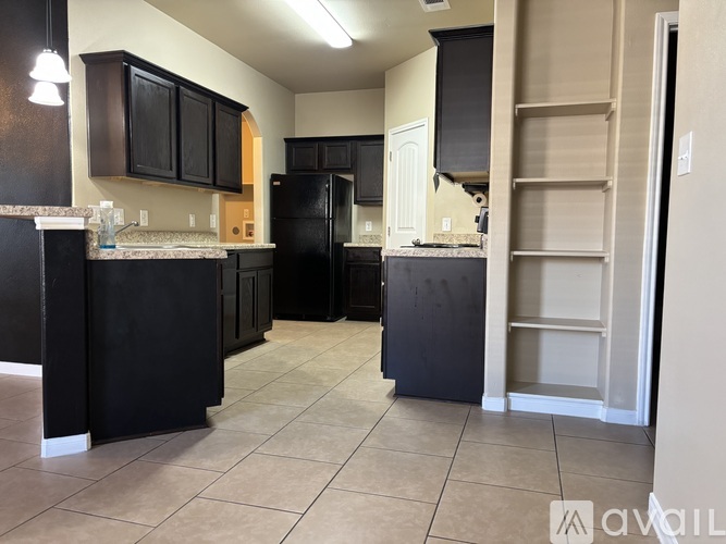 A kitchen with black cabinets and appliances.