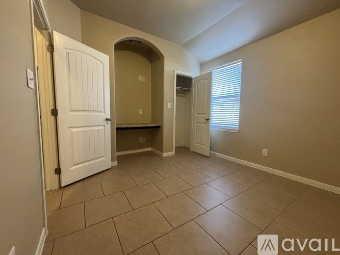 A room with a tiled floor and a doorway leading to another room.
