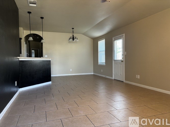 A spacious room with a black counter and tiled floor.