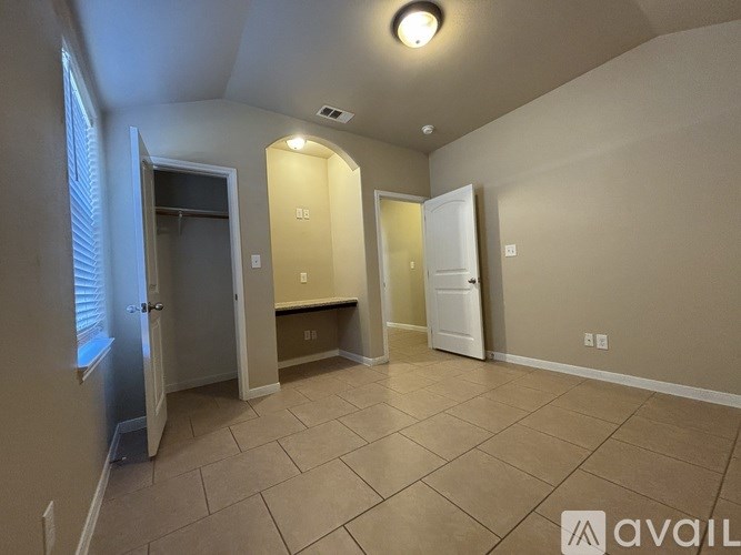A room with a tiled floor and a window on the left side.
