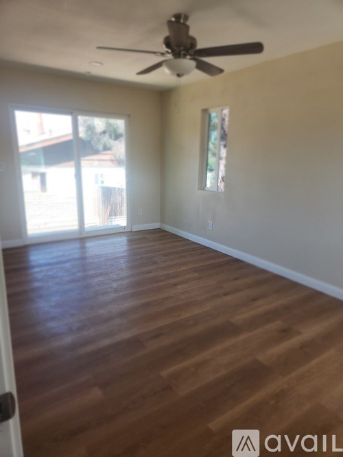 A room with wooden flooring and a ceiling fan.