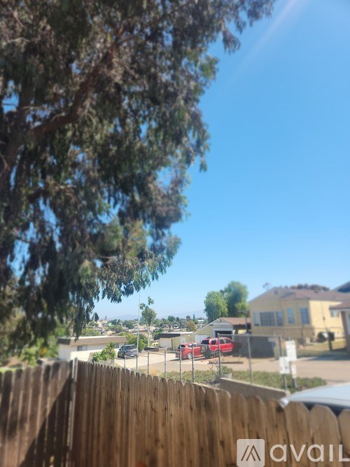 A view of a residential street with cars parked on the side.