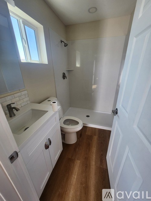 A small bathroom with a toilet, sink, and a window.