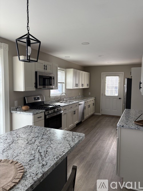 A kitchen with granite countertops and white cabinets.