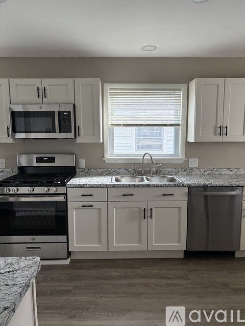 A kitchen with a stove, oven, microwave, and cabinets.