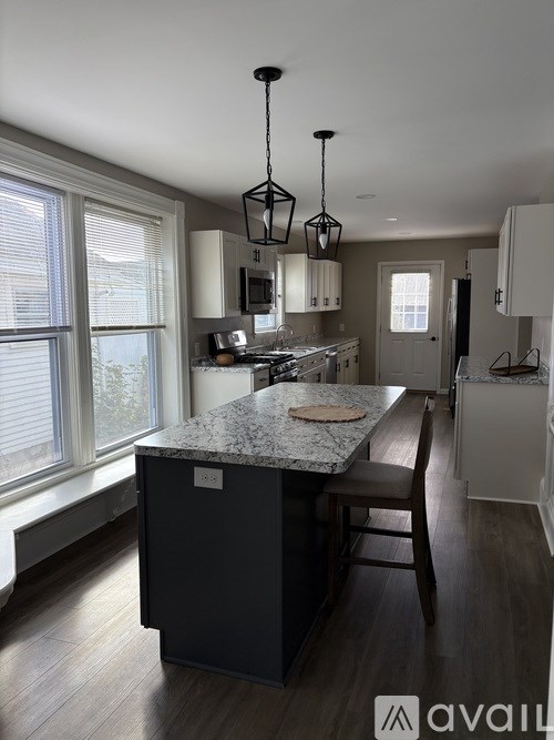 A kitchen with a granite countertop and wooden floors.