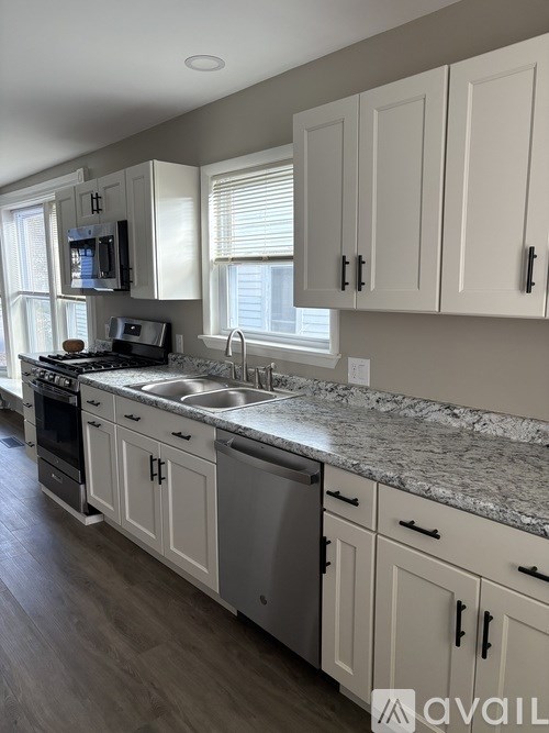 A kitchen with white cabinets and a granite countertop.